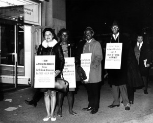 African American and Hispanic American workers on strike against Kellwood, wearing placards that encourage support for better wages
